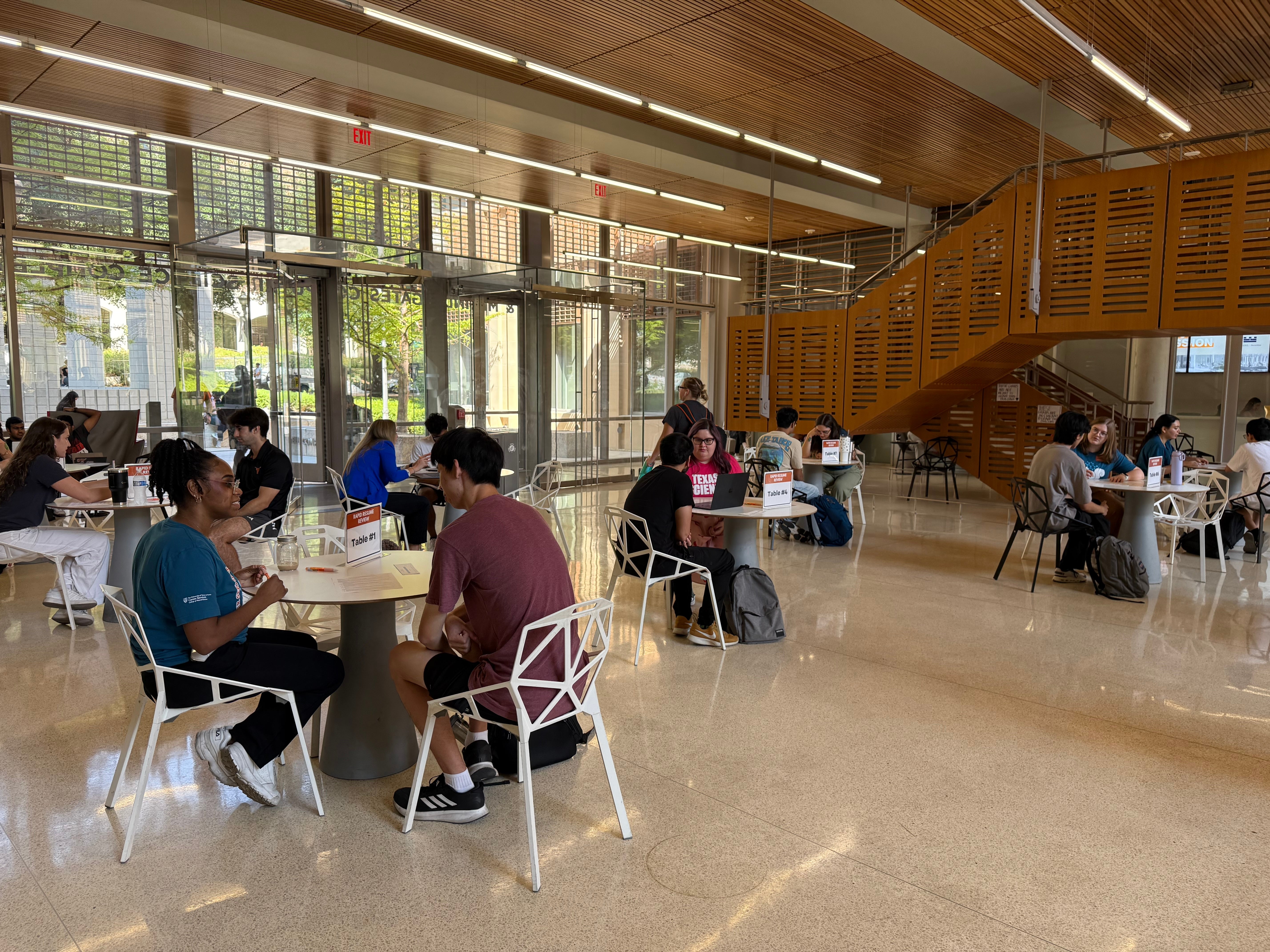 Students reviewing resumes with career coaches in the Gates-Dell Complex Atrium.