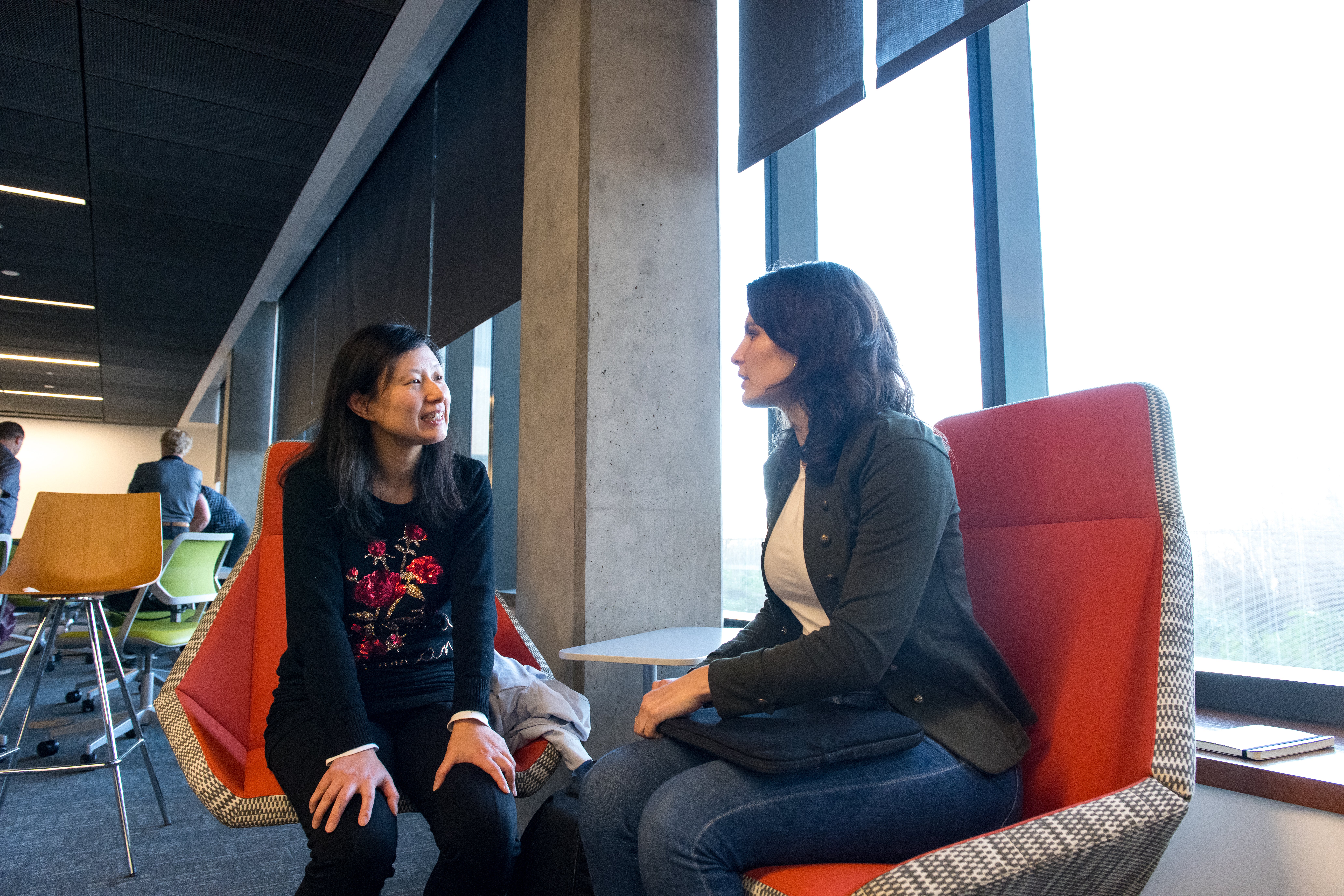 Two people sitting in chairs having a conversation.
